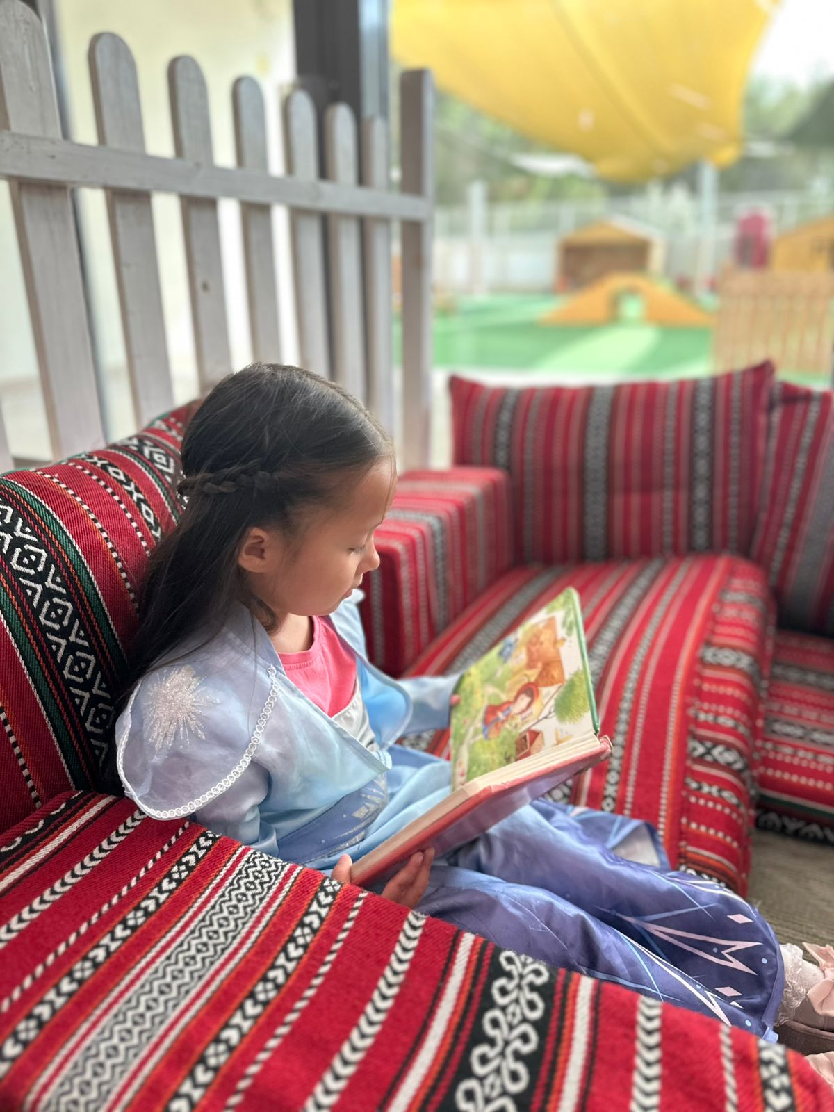 img-3 girl reading a book during quiet time at nursery event